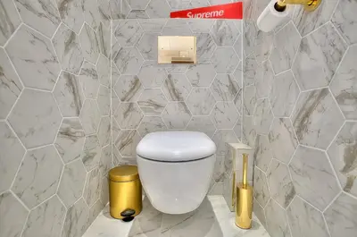 a white toilet in a bathroom with marble walls at Luxury 4 Stars Apartment with 2 Terraces, Cannes Croisette in Cannes