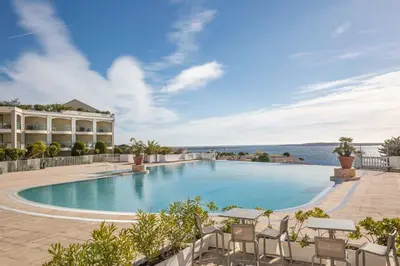 a large swimming pool with chairs and a building at Villa Francia in Cannes