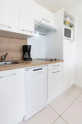 a white kitchen with white cabinets and a sink at Villa Francia in Cannes