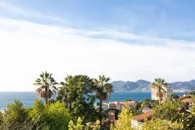 a view of a town with palm trees and the ocean at Villa Francia in Cannes