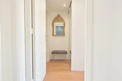 a hallway with a mirror and a chair at 3-Br Apartment Sea View Swimming Pool in Cannes