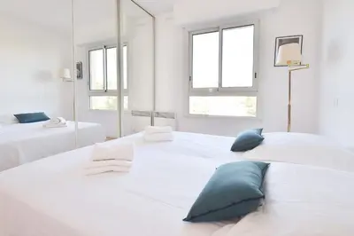two white beds in a white room with windows at 3-Br Apartment Sea View Swimming Pool in Cannes