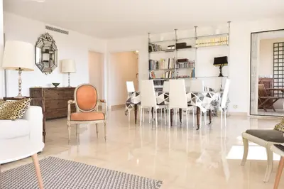 a living room with chairs and a dining room at 3-Br Apartment Sea View Swimming Pool in Cannes