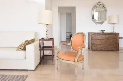 a living room with a chair and a couch at 3-Br Apartment Sea View Swimming Pool in Cannes