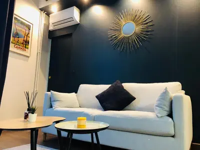 a living room with a couch and two tables at I Cannes Sleep - Centre ville au calme in Cannes