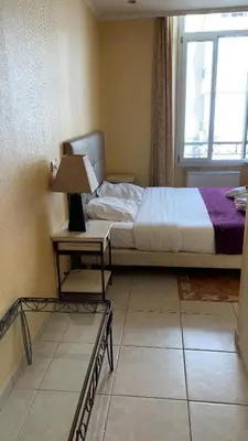 a bedroom with a bed and a table with a lamp at Village Croisette in Cannes
