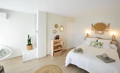 a white bedroom with a bed with two hats on it at le panoramer in Cannes