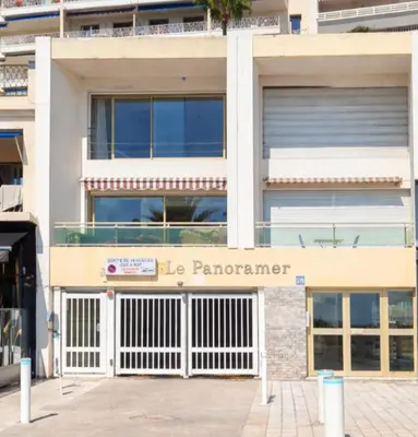 a white building with a fence in front of it at le panoramer in Cannes