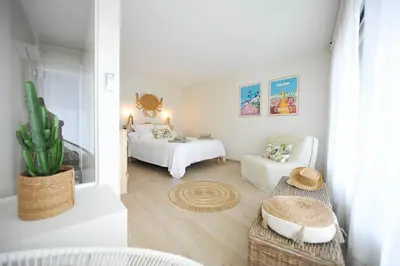 a white bedroom with a bed and a couch at le panoramer in Cannes