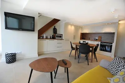 a living room with a table and a kitchen at le panoramer in Cannes