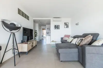 a living room with a couch and a television at LB Vacation Rentals I Admire Panoramic Ocean Views Through Walls of Windows in Cannes