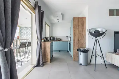a living room with a large window and a kitchen at LB Vacation Rentals I Admire Panoramic Ocean Views Through Walls of Windows in Cannes