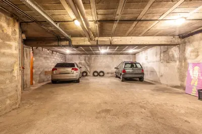 a parking garage with two cars parked in it at LB Vacation Rentals I Admire Panoramic Ocean Views Through Walls of Windows in Cannes