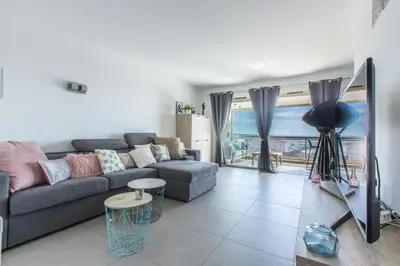 a living room with a couch and a view of the ocean at LB Vacation Rentals I Admire Panoramic Ocean Views Through Walls of Windows in Cannes