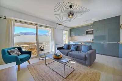 a living room with a couch and a table at IMMOGROOM- Renovated- Large terrace- AC- Shops- Parking in Cannes