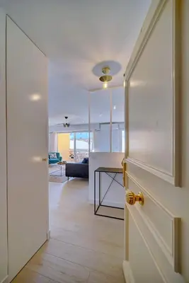 a room with a door and a kitchen with a table at IMMOGROOM- Renovated- Large terrace- AC- Shops- Parking in Cannes