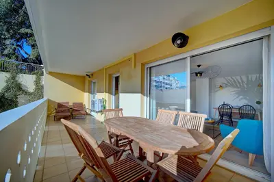 a dining room with a table and chairs on a balcony at IMMOGROOM- Renovated- Large terrace- AC- Shops- Parking in Cannes