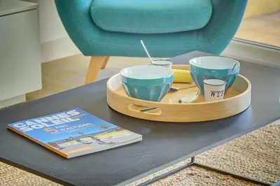 a tray with three glasses and a book on a table at IMMOGROOM- Renovated- Large terrace- AC- Shops- Parking in Cannes