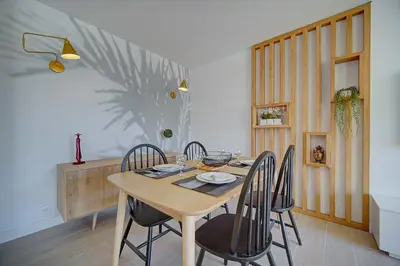 a dining room with a wooden table and chairs at IMMOGROOM- Renovated- Large terrace- AC- Shops- Parking in Cannes