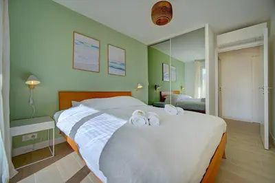 a bedroom with a bed with two towels on it at IMMOGROOM- Renovated- Large terrace- AC- Shops- Parking in Cannes