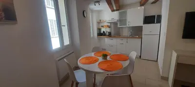 a kitchen with a white table with orange plates on it at le suquet quartier historique in Cannes