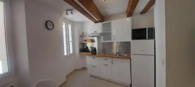 a kitchen with white cabinets and a clock on the wall at le suquet quartier historique in Cannes