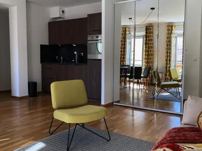 a living room with a yellow chair and a dining room at LE BAIN DE SOLEIL luxury 2 bedrooms Cannes centre in Cannes