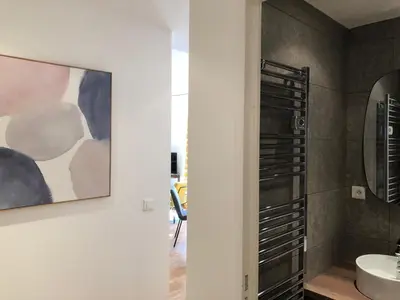 a bathroom with a sink and a painting on the wall at LE BAIN DE SOLEIL luxury 2 bedrooms Cannes centre in Cannes