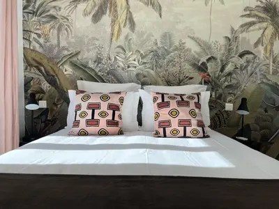 a bedroom with a bed with two pillows and a wallpaper at LE BAIN DE SOLEIL luxury 2 bedrooms Cannes centre in Cannes
