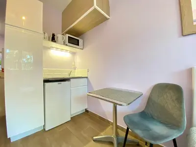 a small kitchen with a table and a chair at Gallia Bella By SCLS Locations in Cannes