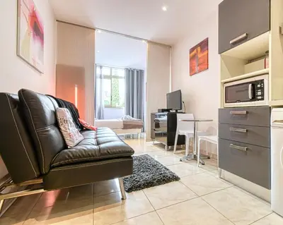 a living room with a leather couch and a table at Beautiful modern apartment in the heart of Cannes in Cannes