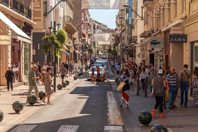 a crowd of people walking down a busy city street at Beautiful modern apartment in the heart of Cannes in Cannes
