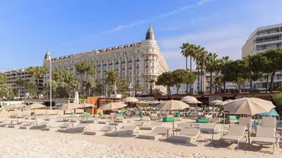 a bunch of chairs and umbrellas on a beach at Beautiful modern apartment in the heart of Cannes in Cannes