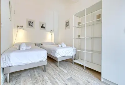 two beds in a room with white walls at Romantic and new apartment in the famous Rue Meynadier in the supercentre of Cannes in Cannes