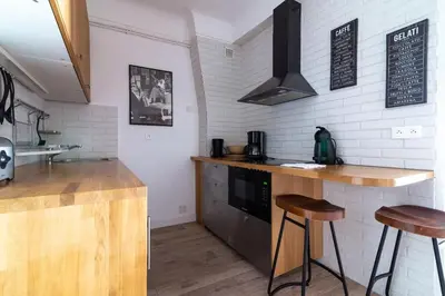 a kitchen with a counter and two bar stools at Romantic and new apartment in the famous Rue Meynadier in the supercentre of Cannes in Cannes