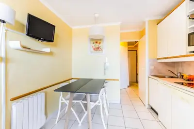 a kitchen with a table and a tv on the wall at Résidence Cannes Villa Francia - maeva Home - Studio 2 Personnes Confort MAE-1845 in Cannes