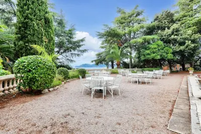 a row of white tables and chairs in a park at Résidence Cannes Villa Francia - maeva Home - Appartement climatisé 3 pièces 4 personnes - Prestige - super Home MAE-6737 in Cannes