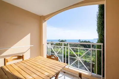 a balcony with a wooden table and a view of the ocean at Résidence Cannes Villa Francia - maeva Home - Appartement 2 pièces 4 personnes - Confort MAE-1762 in Cannes