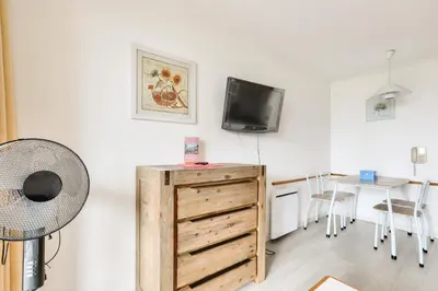 a living room with a tv and a wooden dresser at Résidence Cannes Villa Francia - maeva Home - Appartement 2 pièces 4 personnes - Confort MAE-1762 in Cannes
