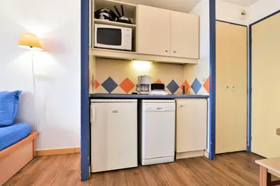 a small kitchen with a refrigerator and a microwave at Résidence Cannes Verrerie - maeva Home - 2 Pièces 5 Personnes Confort MAE-3572 in Cannes