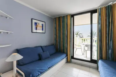 a living room with a blue couch and a balcony at Résidence Cannes Verrerie - maeva Home - Studio 5 personnes Selection MAE-7337 in Cannes