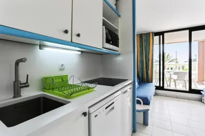 a kitchen with a sink and a view of a patio at Résidence Cannes Verrerie - maeva Home - Studio 5 personnes Selection MAE-7337 in Cannes