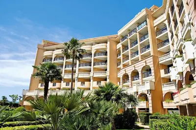 a large building with palm trees in front of it at Résidence Cannes Verrerie - maeva Home - Appartement 3 Pièces 6 Personnes - Selection MAE-0305 in Cannes