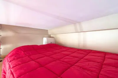 a large red bed in a small room at Beautiful and cozy apartment in the heart of Cannes in Cannes