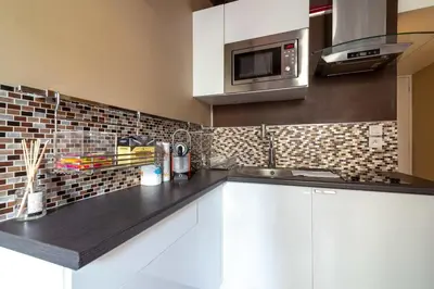 a kitchen with white cabinets and a microwave at Beautiful and cozy apartment in the heart of Cannes in Cannes