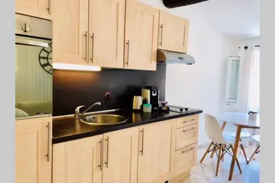 a kitchen with wooden cabinets and a sink and a table at Cannes 78 rue meynadier plage, Mipim Festival 3 minutes à pieds in Cannes