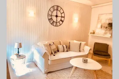 a living room with a couch and a clock on the wall at Cannes 78 rue meynadier plage, Mipim Festival 3 minutes à pieds in Cannes
