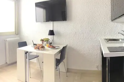 a white table in a kitchen with chairs and a sink at Studio 