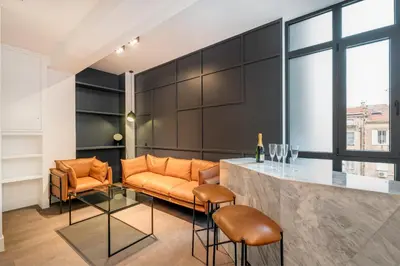 a living room with an orange couch and a bar at RESIDENCE MONTEFIORE in Cannes