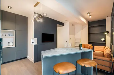 a living room with a blue island with two stools at RESIDENCE MONTEFIORE in Cannes